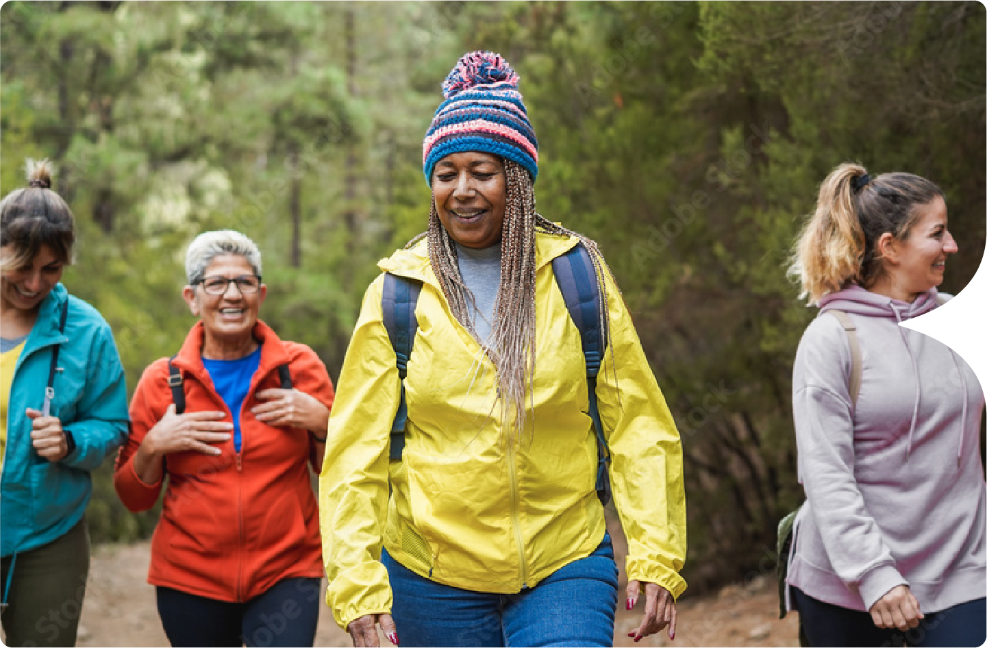 Photograph of four women of varying ages and ethnicities hiking while talking about the FLU SV MRNA-002 Study.